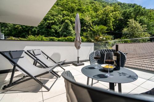 a patio with a table and two chairs and an umbrella at Videre Penthouse Lodge exclusive in Gargazzone
