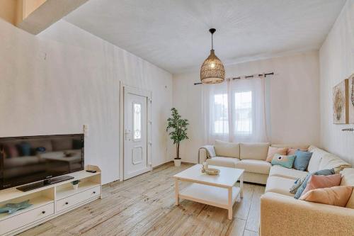 a living room with a couch and a tv at GARBIS HOUSE ( Antiparos Main Street ) in Andiparos