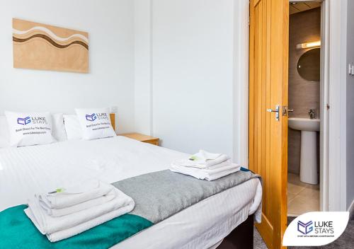 a bedroom with a bed with towels on it at Dene Hotel in Newcastle upon Tyne