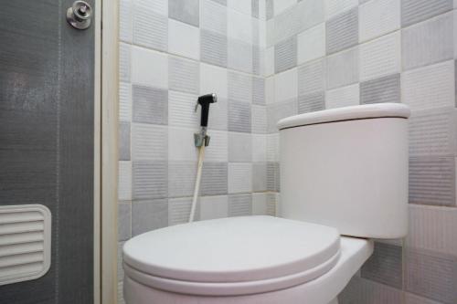 een wit toilet in een badkamer met een dweil bij RedDoorz Syariah near Pasar Godong Grobogan in Bugel