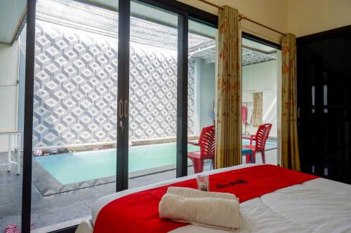 een slaapkamer met een groot raam en een zwembad bij RedDoorz Syariah near Pasar Godong Grobogan in Bugel