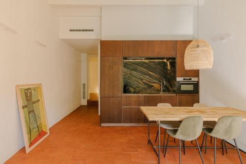 a kitchen and dining room with a wooden table and chairs at Flateli Santa Clara 02 in Girona