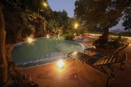 a swimming pool with benches and lights in a park at night at Bella Vista Mahabaleshwar in Mahabaleshwar