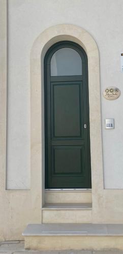 a green door on the side of a building at Palazzo Vecchio Cocumola in Cocumola