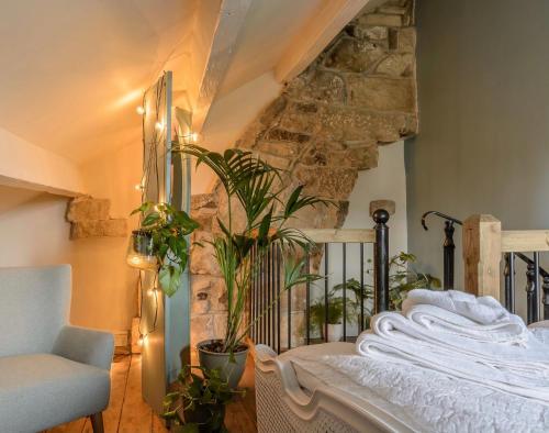 a bedroom with a bed and a stone wall at Romantic cottage, Old Town, Hebden Bridge in Heptonstall