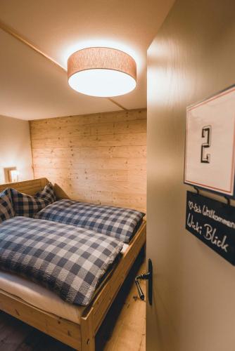 a bedroom with a bed in a room with a wall at Alpenblick Bergrestaurant & Hotel in Arosa
