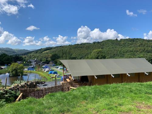 een tent op een heuvel met uitzicht op een rivier bij Quirky Safari Tent with Hot Tub in Heart of Snowdonia in Dolgellau