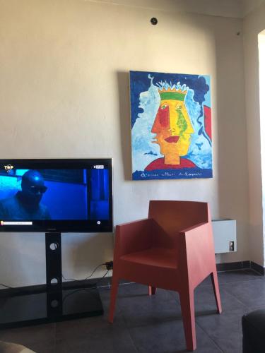 プロプリアノにあるCentro città Apartmentのリビングルーム(テレビ、椅子、絵画付)