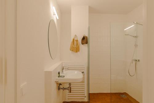 a white bathroom with a sink and a shower at Flateli Santa Clara 12 in Girona