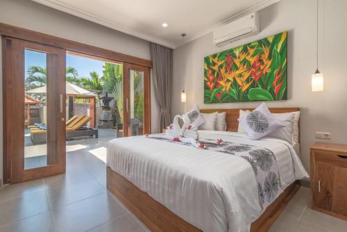 um quarto com uma cama e um quadro na parede em Villa Royal em Singaraja