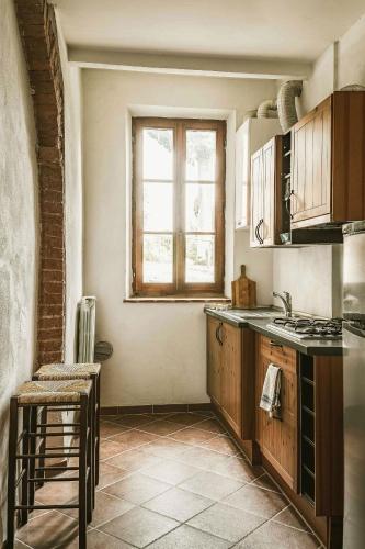 a kitchen with a stove and a window in it at Agriturismo La Torretta in Siena