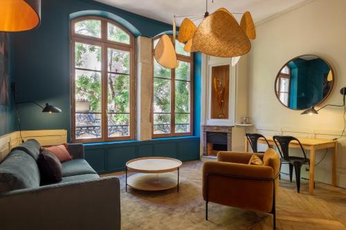 uma sala de estar com um sofá e uma mesa em HONORÊ SUITE SAINT NIZIER em Lyon