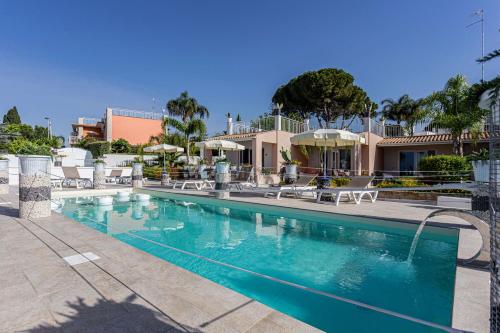 a swimming pool with chairs and umbrellas in a resort at Small Luxury apartments Pool and sea view - Stella Del Mare in Fontane Bianche