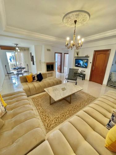 a living room with a large couch and a table at Superbe Appartement Avec Cheminée in Tangier