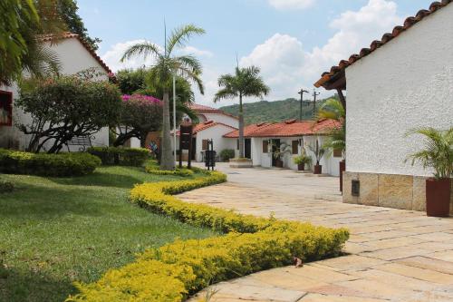 a walkway with yellow flowers next to a building at Hotel San Juan Internacional in Bucaramanga