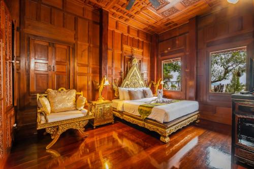 ラワイビーチにあるRoyal Thai Villa Phuket - SHA Extra Plusのベッドルーム(キングサイズベッド1台、椅子付)