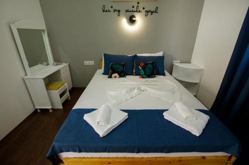 a bedroom with a bed with blue sheets and towels at Adrasan Luna Aicha 1 in Adrasan