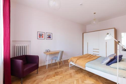 a bedroom with a bed and a chair and a desk at Art & Comfort Home in Kaunas