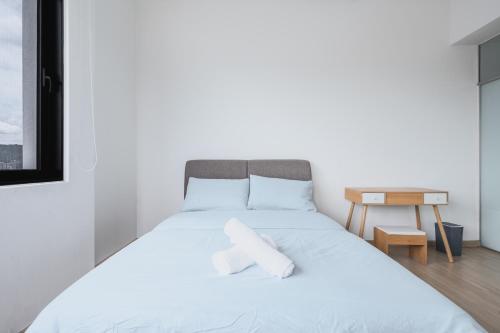 a bedroom with a bed with two white towels on it at Encorp Strand Residences by Airhost in Kota Damansara