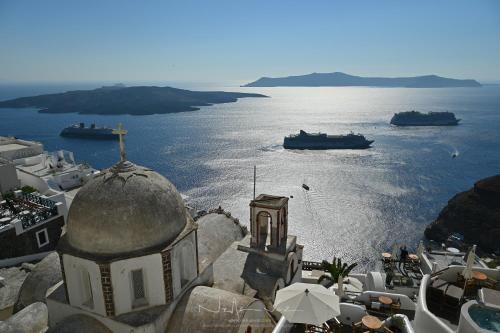 a view of the water with boats in the ocean at DELION VIEW HOTEL in Fira