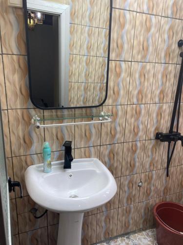 a bathroom with a white sink and a mirror at RÉSIDENCE MARTHA in Yaoundé