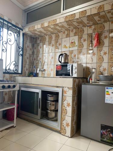 a kitchen with a stove and a microwave at RÉSIDENCE MARTHA in Yaoundé