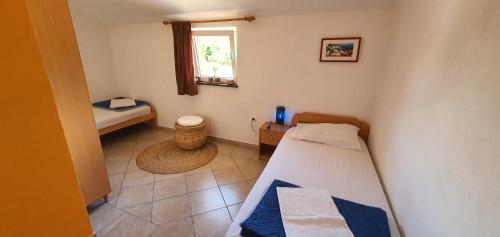 um pequeno quarto com uma cama e uma janela em Apartments Kalac em Posedarje