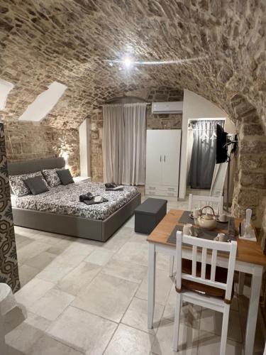 a bedroom with a bed and a table in a room at La Maison da Francy in Bitetto