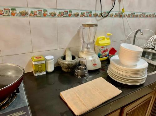 a kitchen counter with plates and a blender on it at A famosa resort villa 1054 in Kampong Alor Gajah