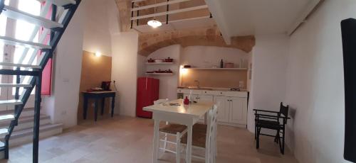 een keuken met een tafel en stoelen en een keuken met een trap bij Corte SantAngelo 15 in Tricase