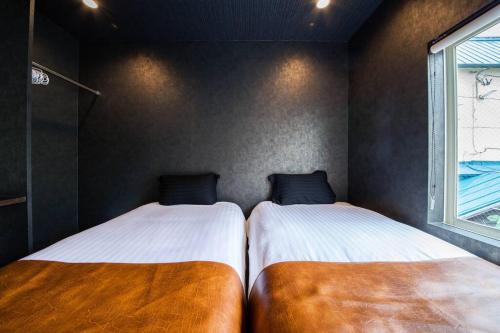 two beds sitting next to each other in a room at THE BEEHIVE AIOI in Otaru