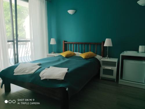 a blue bedroom with a large bed with pillows at OLECKI Holiday House in Dźwirzyno