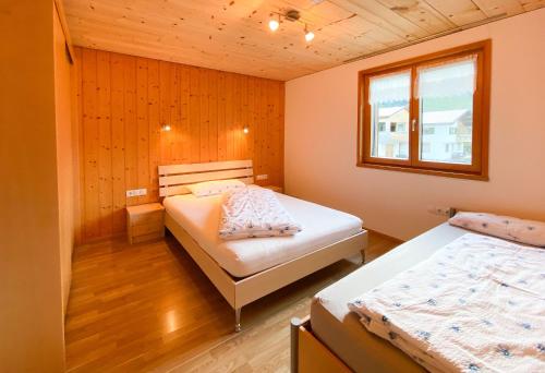 Un dormitorio con dos camas y una ventana. en Haus Helga, en Schoppernau
