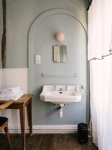 La salle de bains est pourvue d'un lavabo et d'une table. dans l'établissement La Maison Pieuse, à Villiers-Saint-Benoît