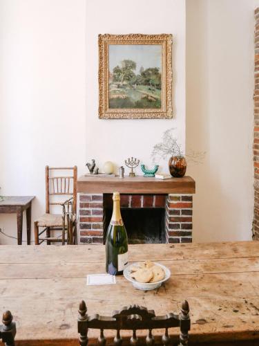 une salle à manger avec une table et une bouteille de vin dans l'établissement La Maison Pieuse, à Villiers-Saint-Benoît