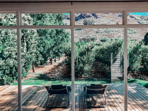 a glass table and chairs in front of a window at Gite in Franschhoek