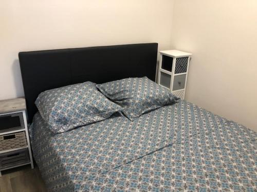 ニースにあるEROSのベッドルーム1室(黒いヘッドボードと枕付きのベッド1台付)