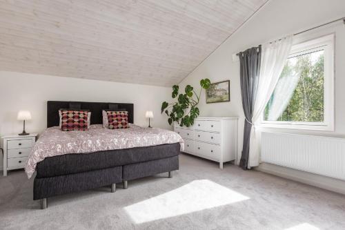 Modern holiday home in Kisa في Kisa: غرفة نوم بسرير كبير ونافذة