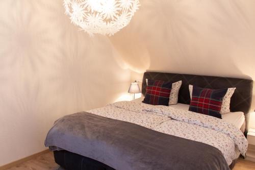 1 dormitorio con cama y lámpara de araña en Hof Timmermann - Heuboden, en Ottenstein