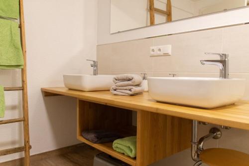 a bathroom with a sink and towels on a wooden counter at Hof Timmermann - Spatzennest in Ottenstein