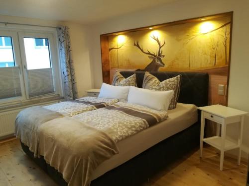 a bedroom with a large bed with a antler headboard at Hof Timmermann - Bienenstock in Ottenstein