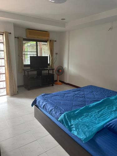 a bedroom with a bed and a flat screen tv at TG2 - Tientong Guesthouse 2 in Hua Hin