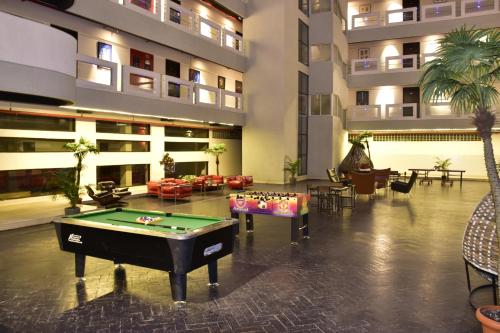 The Fern Residency, Vadgaon - Talegaon, Pune في بيون: لوبي الفندق مع طاولة بلياردو في المنتصف