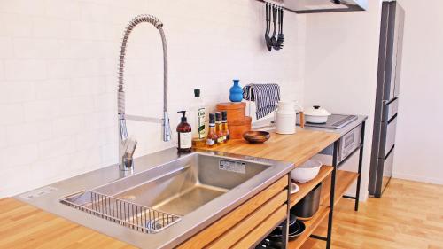 a kitchen with a stainless steel sink and a counter at The Resort Villa Kochibanta Okinawa in Kudeken