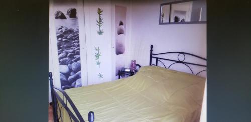 un lit dans une chambre avec un tableau sur le mur dans l'établissement face à la mer, à Propriano