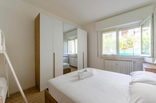sypialnia z białym łóżkiem i oknem w obiekcie JOIVY Banfi Apartment w Rapallo