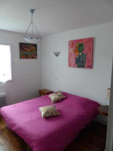 a bedroom with a purple bed with two pillows on it at LA MAISON BLEUE in Arzon