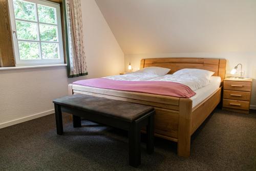 1 dormitorio con cama con banco y ventana en Ferienwohnungen Zum Hülsenbusch, en Bispingen