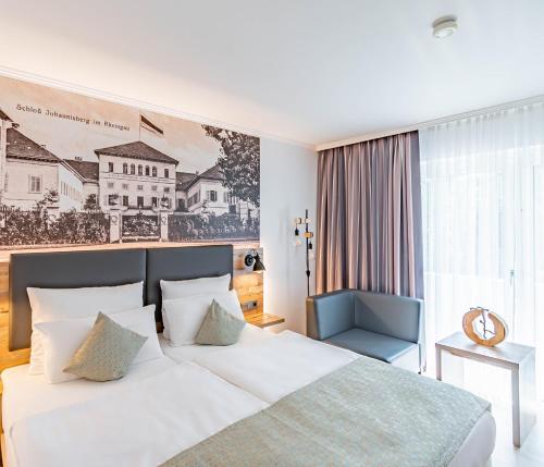 a bedroom with a white bed and a blue chair at Parkhotel Sonnenberg in Eltville