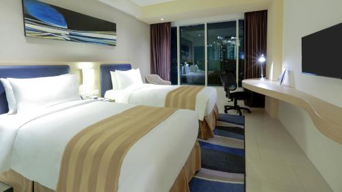a hotel room with two beds and a television at Holiday Inn Express Jakarta International Expo by IHG in Jakarta